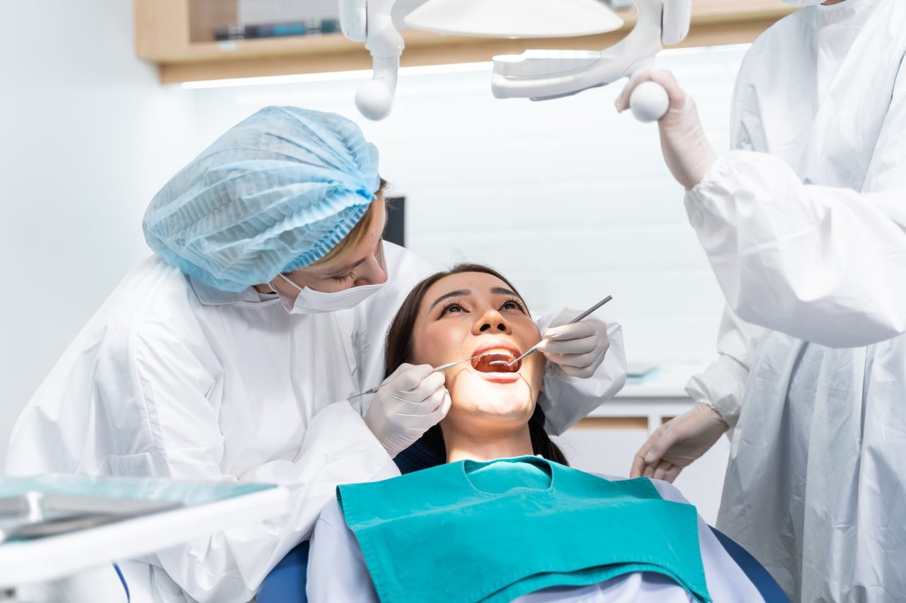 caucasian dentist examine tooth for young girl at dental health clinic